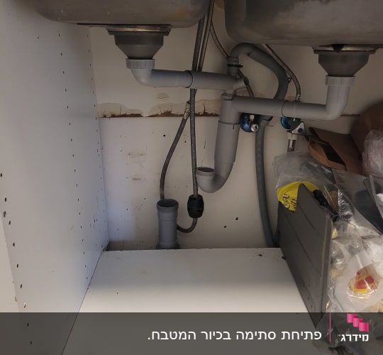 מערכת צנרת וסיפון מנותקת מתחת לכיור מטבח כפול